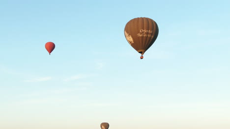 Tiro-Aéreo-Inclinado-Hacia-Abajo-De-Globos-Aerostáticos-Que-Vuelan-Sobre-El-Paisaje-Escénico-De-Myanmar-Durante-El-Amanecer-En-La-Mañana