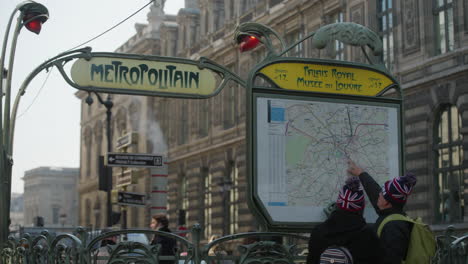 English-tourists-looking-at-the-city-subway-network-in-Paris,-France