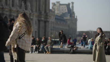 Tourist-man-takes-a-photo-of-his-partner-in-front-of-the-louvre