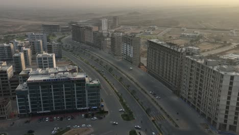 Vuelo-Aéreo-De-Regreso-Sobre-Apartamentos-Y-Desarrollos-De-Edificios-En-La-Ciudad-De-Bahria-En-Karachi-Durante-La-Puesta-De-Sol