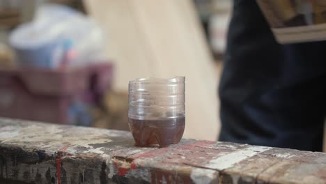 Gießen-Sie-Dänisches-Öl-In-Einen-Plastikbecher