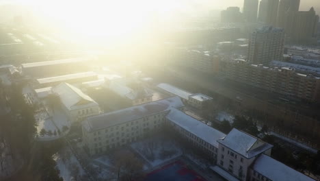 High-key-sun-flare-in-fog-on-icy-cold-winter-morning-city-aerial