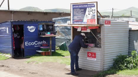 Hombre-Africano-En-Lesotho-Completa-El-Papeleo-En-El-Quiosco-De-Teléfonos-Celulares