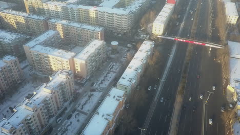 Winter-morning-aerial-over-multi-lane-highway-and-apartment-blocks