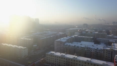 High-key-sun-flare-aerial-over-cold-winter-city-aerial,-northern-China