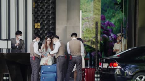 hotel-staff-welcoming-and-assisting-guests-with-their-luggage-in-front-of-a-luxurious-hotel