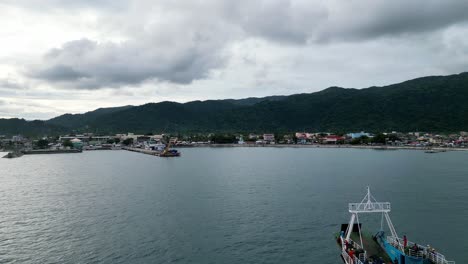 Aerial-Establishing-View-of-Passenger-Ferry-Boat-sailing-towards-port-of-idyllic-rural-town-in-the-island-of-Catanduanes,-Philippines