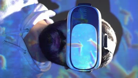 Man-wearing-virtual-reality-headset,-fish-in-aquarium-swimming-overlay