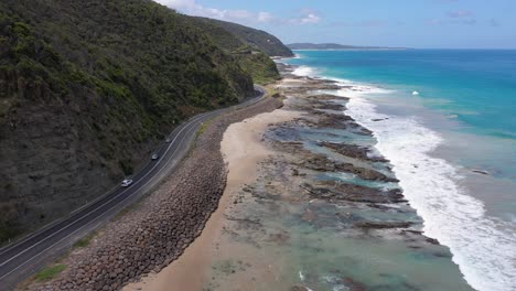 Great-Ocean-Road-aerial-view-with-cars-and-beach,-Victoria,-Australia