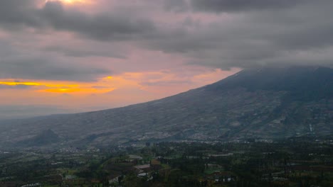 Time-lapse-shot-of-orange-colored-sunrise-covered-by-dense-clouds-over-mountain-in-Indonesia
