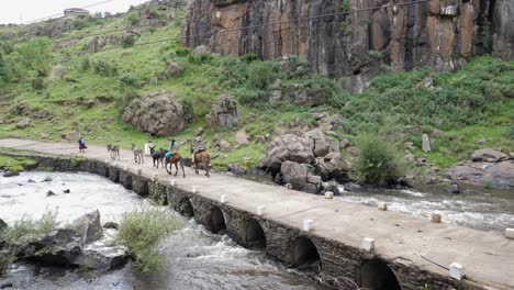 Los-Lugareños-Bantú-Montan-Caballos-A-Través-Del-Puente-Del-Río-En-Las-Zonas-Rurales-De-Lesotho,-África