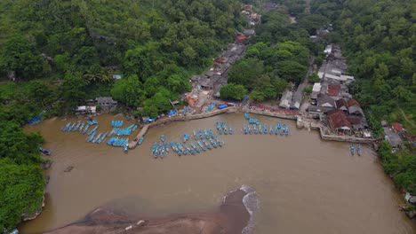 Aerial-view-of-harbour-with-Rows-of-blue-fishing-boats-anchored-on-it