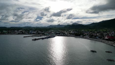 Filmische,-Luftaufnahme-Der-Weiten-Meeresbucht-Neben-Der-Idyllischen-Inselstadt-Virac,-Catanduanes,-Mit-Bangka-Booten,-Einfachen-Häusern-Und-Dramatischen-Wolken