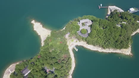 Flyover-of-traditional-buildings-on-small-islet,-Thousand-Island-Lake