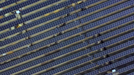 Módulos-Fotovoltaicos-Solares-Instalados-En-Una-Planta-De-Generación-De-Energía,-4k,-Video-Aéreo,-Vista-Aérea-Cuando-Se-Mueve-La-Parte-Superior-Con-Rotación-Alejada