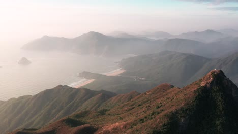 Aerial-flyover-of-sharp-peak,-mist-covered-Big-Wave-Bay-Sai-Kung-Hong-Kong