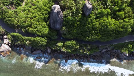 Vogelperspektive-Auf-üppige-Vegetation,-Riesige-Granitfelsen-Und-Straße-In-Der-Nähe-Der-Klippe-Am-Anse-Forbans-Beach-Mahe,-Seychellen