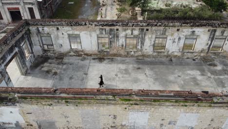 Rotating-aerial-shot-of-a-couple-walking-through-an-abandoned-building