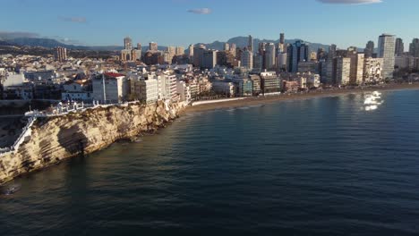 The-popular-tourism-city-of-Benidorm,-Spain---aerial-view-of-the-coastal-cliffs