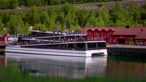 People-boarding-modern-ferry-in-Norway,-fusion-time-lapse