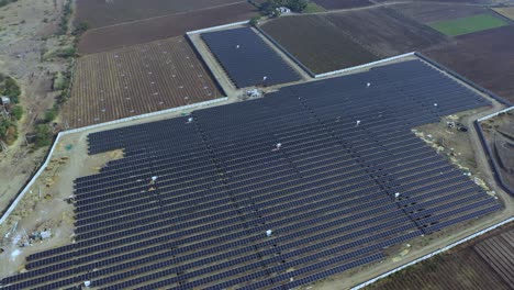 Aerial-view-of-large-sustainable-electrical-power-plant-with-rows-of-solar-photovoltaic-panels-for-producing-clean-electric-energy