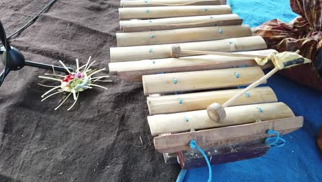 Closeup-of-Bali-Gamelan-Music-Instrument-Gambang-made-of-Bamboo-next-to-Flower-Offerings,-Balinese-Culture,-Indonesia