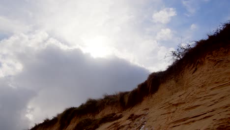 Coastal-erosion-of-Sandunes-on-Hemsby-Beach,-with-sun-breaking-through-the-clouds