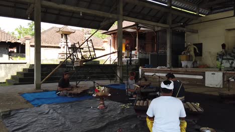 Gamelan-Music-Teacher-Shows-How-to-Play-Music-in-Bali-Indonesia-wearing-Traditional-Clothes,-Sidemen-Village