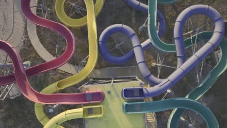 Aerial-top-down-shot-of-old-empty-water-park-with-colorful-chutes