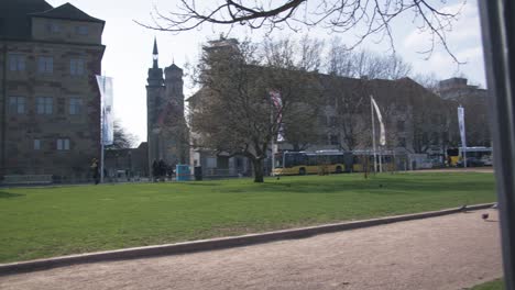 Frauen-Unterhalten-Sich-Auf-Einer-Bank-Im-Park-Und-Beobachten-Den-Verkehr-–-Schlossplatz-In-Der-Innenstadt-Von-Stuttgart-In-4K,-Klassische-Deutsche-Architektur,-Berühmt,-Rotes-Komodo-Cooke-Mini-S4i-Objektiv-In-Premiumqualität-|-Nachricht