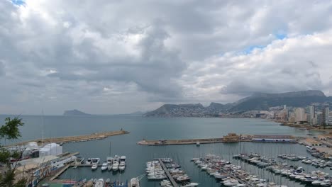 Pano-view-of-Calpe-and-fishing-harbour,-evening-clouds-starting-to-form-over-the-blue-sea