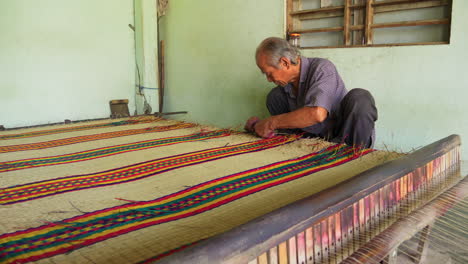 Hombre-Asiático-Haciendo-Colchones-Hechos-A-Mano,-Cortando-Hebras-Sueltas-De-La-Alfombra