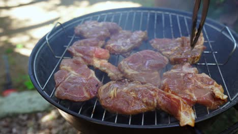 Putting-pork-chops-on-home-charcoal-bbq-grill