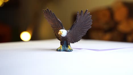 Kleiner-Spielzeug-Weißkopfseeadler-Dreht-Sich-Vor-Dunklem-Hintergrund