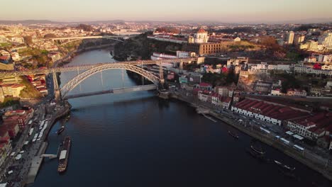 Atemberaubende-Drohnenaufnahmen-Bei-Sonnenuntergang-Des-Flusses-Douro-Im-Herzen-Von-Porto,-Portugal