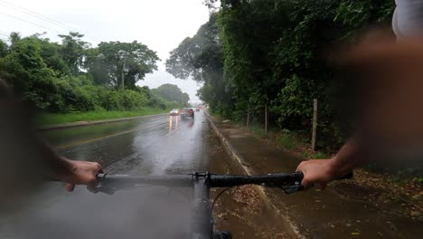 Ciclista-En-Una-Carretera-Con-Lluvia-Y-Tráfico-De-Coches,-Vista-En-Primera-Persona