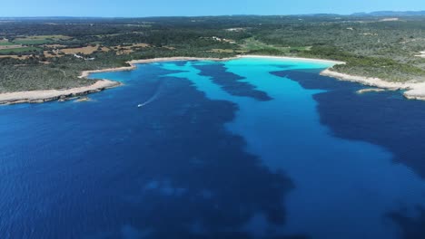 Aerial-view-displaying-the-white-sand-beach-and-crystal-clear-bay-in-Menorca-Spain