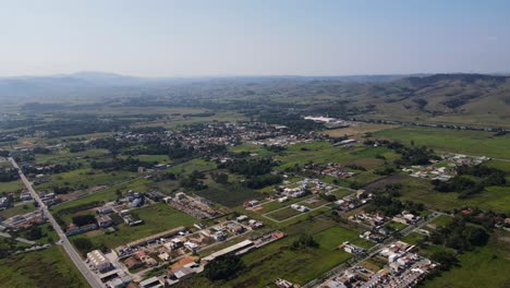 Vista-Aérea-De-Un-Pequeño-Pueblo-En-El-Campo-Con-Pocas-Casas-Y-Mucho-Espacio-Verde-Disponible-Para-Vivienda-En-El-Fondo-De-Las-Montañas-En-Un-Día-Soleado-En-La-Tarde-Brasil-Porto-Real