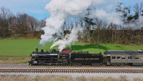 A-Drone-Slow-Motion-View-of-a-Steam-Passenger-Train,-Coming-to-a-Stop,-at-Small-Train-Station-on-a-Sunny-Fall-Day