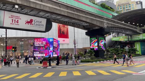 Panning-view-of-Bukit-Bintang-Monorail-station-and-the-street-crossing-scene-at-the-famous-Shibuya-Style-intersection-in-Kuala-Lumpur,-Malaysia