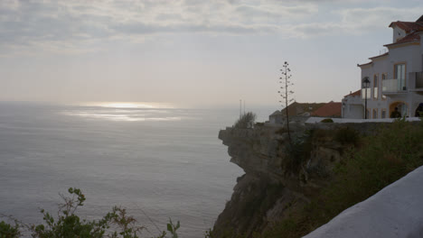 Cliff-edge-overlooking-ocean-on-cloudy-day-in-town-of-Nazare,-Portugal