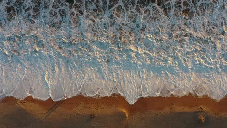 Stunning-drone-view-over-a-tropical-beach-with-waves-at-sunset-on-the-Pacific-coast-in-Mexico