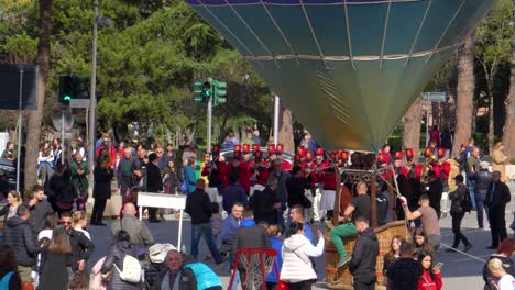 Coloridas-Festividades-De-Primavera-En-Tirana:-Gente-Celebrando-Con-Una-Banda-De-Música-Y-Globos-En-El-Aire