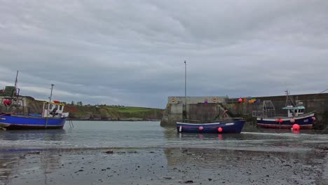 Boatstrand-Copper-Coast-Waterford,-low-tide-with-fishing-boats-resting-on-the-sand-in-the-harbour