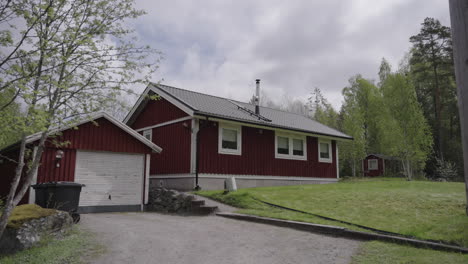 Ein-Charmantes-Schwedisches-Rotes-Haus,-Eingebettet-In-Eine-Friedliche-Waldlandschaft,-Das-Ein-Gemütliches-Und-Einladendes-Sommerhaus-Bietet.-Nordische-Architektur-Mit-Einem-Gemütlichen-Und-Einladenden-Innenraum,-üppigem-Grün-Und-Natürlicher-Schönheit