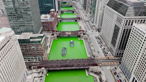 Aerial-view-overlooking-ferries-on-the-Dyed-Chicago-river-on-St