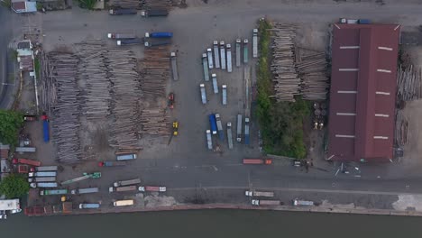 Timber-waiting-to-be-exported-at-port-area-along-the-Saigon-river-in-Ho-Chi-Minh-City,-Vietnam