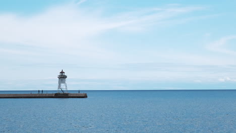 People-visiting-a-small-lighthouse-on-open-water