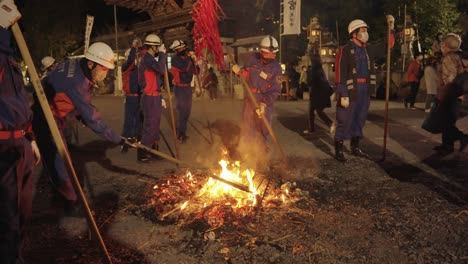 Fireman-rack-the-coals-of-remains-of-Sagicho-Matsuri-Bonfire