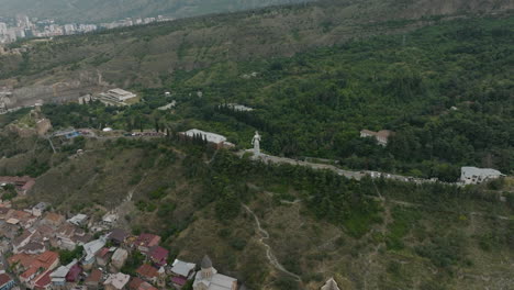 High-angle-aerial-shot-of-the-Tbilisi-landscape-and-the-Kartlis-Deda-statue